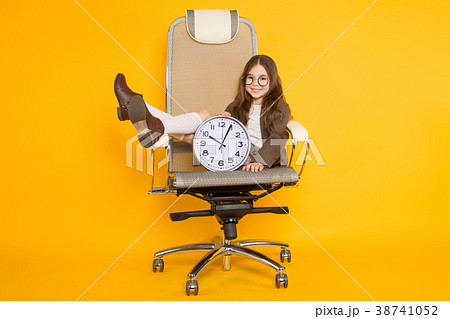 Little brunette girl with clocks in chair 38741052