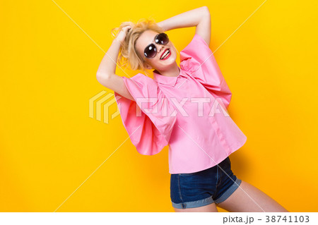 Happy blonde woman in pink blouse with sunglasses 38741103