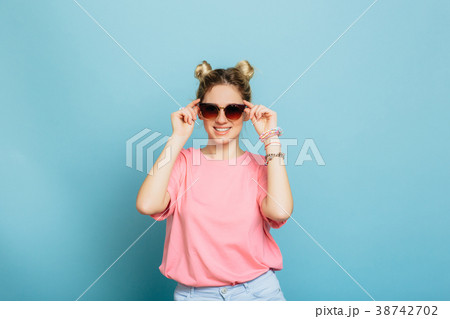 woman dressed in sunglasses on a blue background 38742702