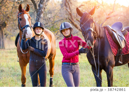 Two teenage girls with their horse in park Two teenage girls with their horse in park 38742861