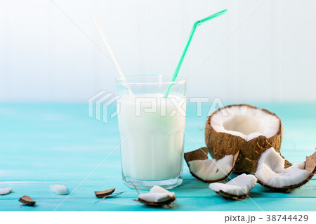 Glass of coconut milk on blue wooden table Glass of coconut milk on blue wooden table 38744429