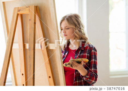 student girl with easel painting at art school 38747016