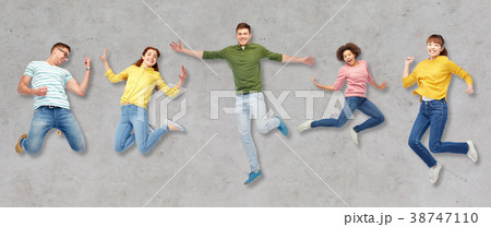happy people or friends jumping in air over gray 38747110