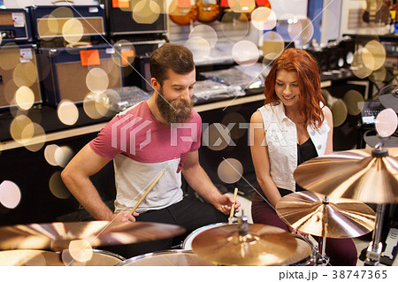 happy man and woman playing cymbals at music store happy man and woman playing cymbals at music store 38747365