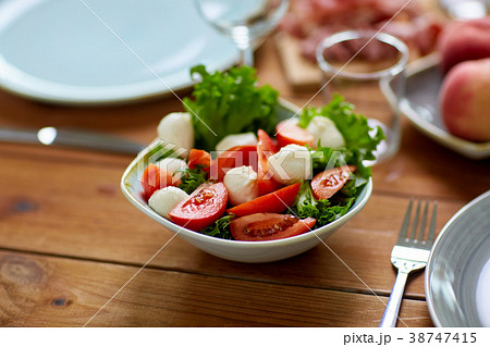 vegetable salad with mozzarella on wooden table vegetable salad with mozzarella on wooden table 38747415