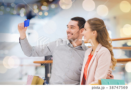 happy couple with smartphone taking selfie in mall happy couple with smartphone taking selfie in mall 38747569