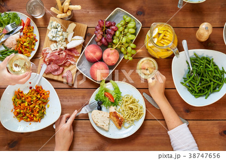 group of people eating at table with food 38747656