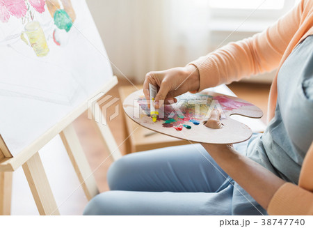artist applying paint to palette at art studio artist applying paint to palette at art studio 38747740