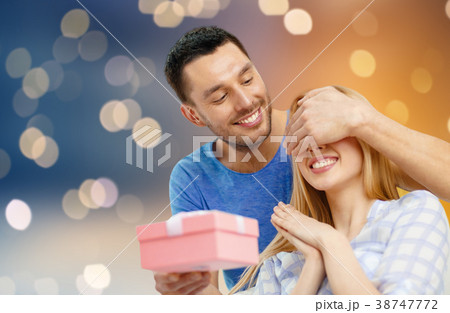 happy couple with present over lights background happy couple with present over lights background 38747772