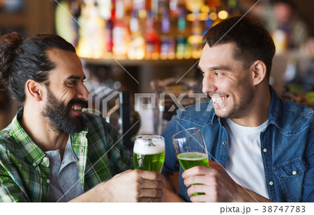 male friends drinking green beer at bar or pub 38747783