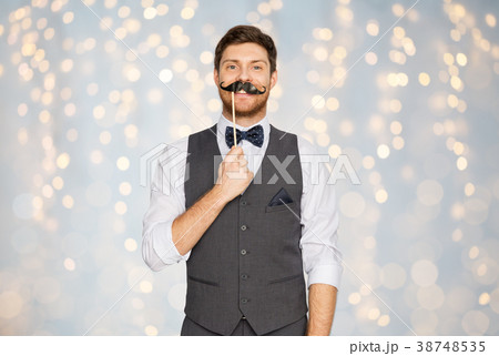 happy young man with fake mustache at party happy young man with fake mustache at party 38748535