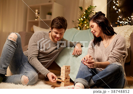 happy couple playing block-stacking game at home happy couple playing block-stacking game at home 38748852