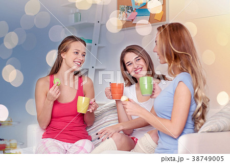 happy young women drinking tea with sweets at home 38749005