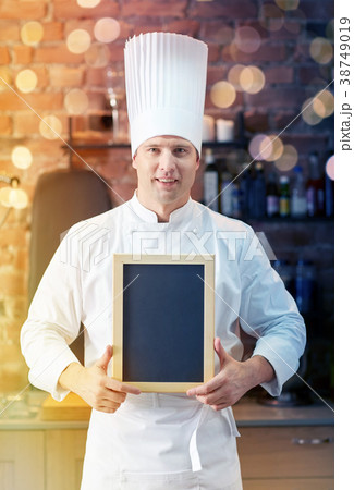 happy male chef with blank menu board in kitchen happy male chef with blank menu board in kitchen 38749019