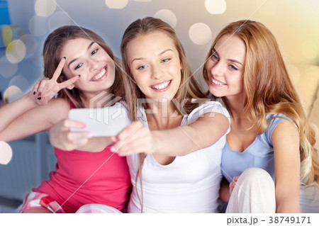 teen girls with smartphone taking selfie at home teen girls with smartphone taking selfie at home 38749171