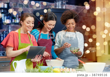 happy women with tablet pc cooking in kitchen happy women with tablet pc cooking in kitchen 38749516