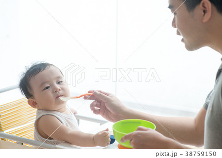 Father feeding child food. 38759150