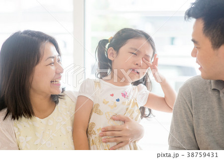 Parents comforting crying daughter 38759431