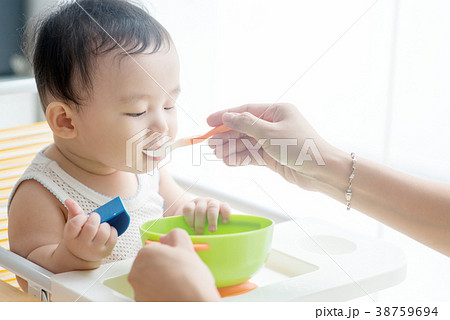 Mother feeding son. 38759694