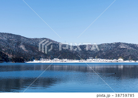 冬の余呉湖と雪の集落の写真素材