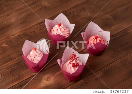 Pink cupcakes on wooden background Pink cupcakes on wooden background 38767237