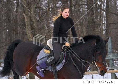 A girl on a horse jumps over the barrier. A girl on a horse jumps over the barrier. 38767781