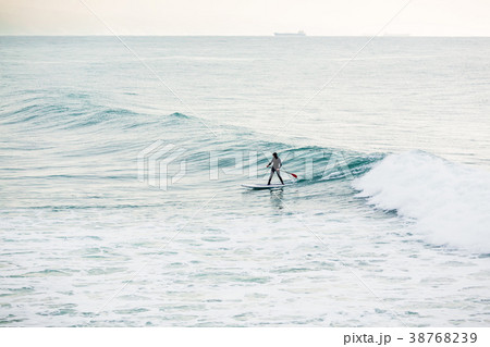 Surfer on sup board on ocean waves. 38768239