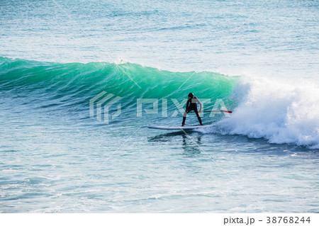 Surfer ride on stand up paddle board on ocean wave 38768244