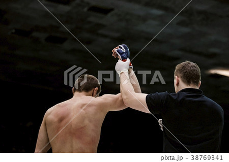referee lifting hand of victorious fighter referee lifting hand of victorious fighter 38769341
