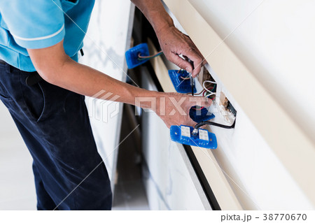 electricity work with man fixing outlet  38770670