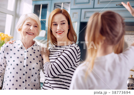 Cheerful mother and grandmother listening to 38773694