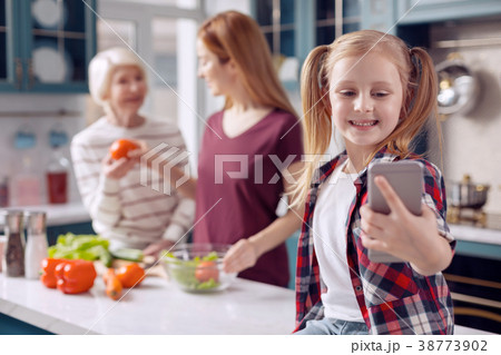 Smiling girl taking selfie while mother and Smiling girl taking selfie while mother and 38773902