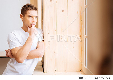 Troubled young man looking out the window 38775153