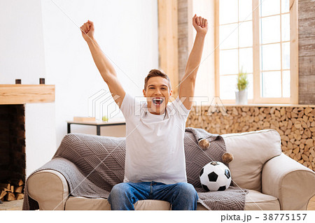 Happy teenager watching football at home Happy teenager watching football at home 38775157