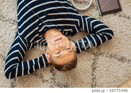 Serious teenager lying on the floor and thinking Serious teenager lying on the floor and thinking 38775496