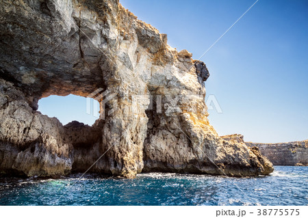 Window in a cliff at the seashore of Comino Island 38775575