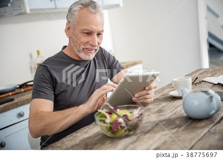 Attentive male person using tablet Attentive male person using tablet 38775697