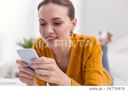 Kind attractive woman concentrating on phone 38776976