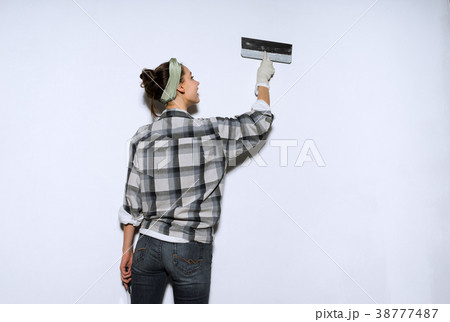 girl painterleveling the walls with a spatula, girl painterleveling the walls with a spatula, 38777487