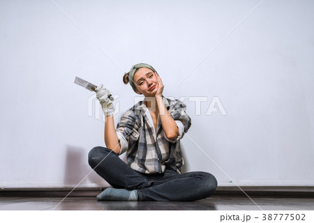 girl is sitting on the floor holding a spatula 38777502