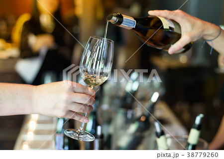 pouring wine from the bottle into glasses 38779260