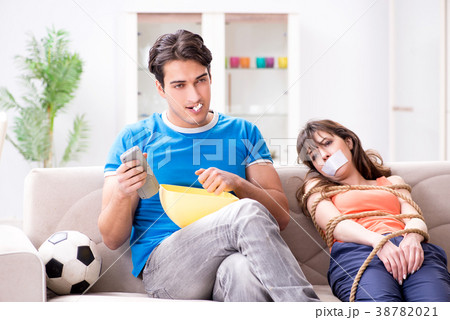 Man tying up his wife to watch sports football Man tying up his wife to watch sports football 38782021