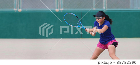 バックハンドを打つ女子ジュニアテニスプレイヤーの写真素材