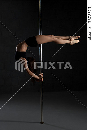 Slim girl in top and shorts exercising on pylon 38783254