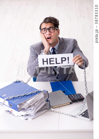 Busy employee chained to his office desk 38783310