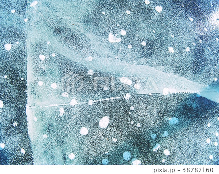 Bubbles frozen in thin ice. Colorful piece of ice 38787160