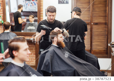 man getting trendy haircut at barber shop. man getting trendy haircut at barber shop. 38787523