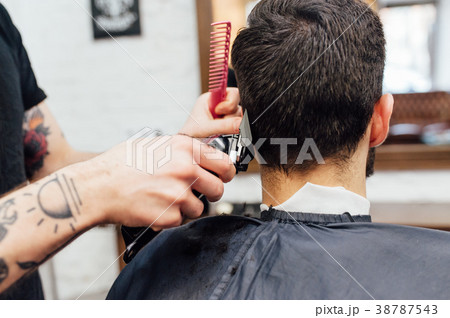 man getting trendy haircut at barber shop. 38787543