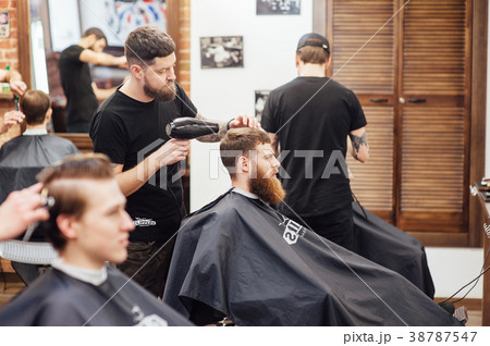 man getting trendy haircut at barber shop. 38787547