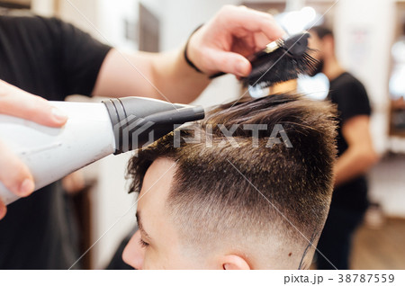 man getting trendy haircut at barber shop. man getting trendy haircut at barber shop. 38787559
